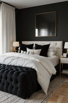 a bedroom with black walls, white bedding and an upholstered tufted ottoman