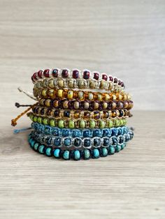 the multicolored beaded bracelets are stacked on top of each other