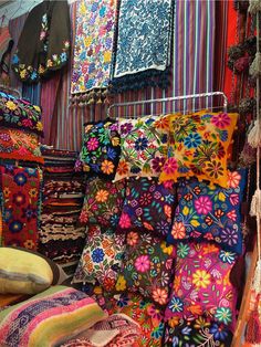 colorful fabrics and rugs on display in a store