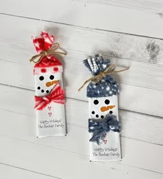 two snowmen wrapped in red, white and blue paper are sitting next to each other