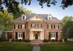 a large brick house with white trim and black shutters