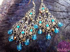 These Antique Brass Filigree Moroccan Boho Chandelier Earrings are made with hand-antiqued brass filigrees tiered to form a beautiful classic chandelier shape. Peacock Teal, Garnet Red and Metallic Gold crystal beads hang on each tier. Swarovski rhinestones add a touch of sparkle! Available Bohemian Earrings With Peacock Design For Celebrations, Bohemian Peacock Design Earrings For Celebration, Festive Bohemian Jeweled Earrings, Bohemian Jeweled Chandelier Earrings As Gift, Festive Bohemian Chandelier Earrings With Intricate Design, Festive Bohemian Chandelier Earrings With Dangling Beads, Bohemian Festive Chandelier Earrings For Celebration, Festive Bohemian Chandelier Earrings For Celebration, Bohemian Chandelier Earrings With Filigree For Parties