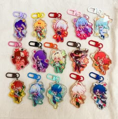 a collection of cartoon character shaped keychains on a white cloth covered tablecloth