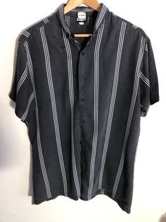 "Vintage Kudo S Black and Grey Striped Short Sleeve Shirt Made in the USA 50% Rayon, 50% Polyester There is minor piling on the shirt Size Large Measurements taken while laying flat Neck 5\" Pit to Pit 24\" Sleeves from pit to bottom 6\" Length from shoulder to bottom 29\" Purchase price includes free shipping in Canada and the USA International shipping is available, please contact before purchase for shipping quote Any questions, just ask! Vintage item, regular wear due to age should be expected Any known flaws/markings will be listed No returns/exchanges, but please contact if there is an issue with your item" Tan Pants, Striped Short Sleeve Shirt, Grey Crewneck, Black And White Tops, Basic Grey, Striped Short, Grey Stripes, White Tops, Short Sleeve Shirt