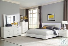 a bedroom with gray walls and white furniture