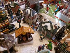 an assortment of christmas village figurines on display