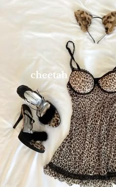 a leopard print dress and high heels on a bed