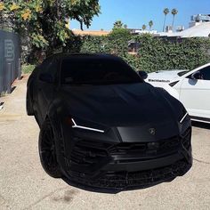 a black sports car parked in front of some white cars