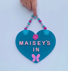 a blue heart shaped sign that says maisey's in pink and blue beads