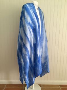 "Our lightweight 100% silk kimono wrap is handpainted in refreshing shades of blue and white.  It is 100% habotai silk with a beautiful drape designed for every body. Length is approximately 35\" from the shoulder.  We are two sisters living on the sunny Gulf Coast of Florida. We use our background as water-colorists to paint our unique silk kimono wraps and our watercolor earrings. Our work reflects the grace and movement of water that so inspires us.  The silk kimonos are painted by hand using silk dyes and the magical addition of salt.  We then sew our silks into these wonderful, elegant, and  lightweight kimono- style wraps that truly fit every body! Silk kimono care: Handwash and hang to dry. Iron on silk setting with steam." Blue Silk Kimono For Vacation, Blue Silk Scarf For Beach In Spring, Hand Painted Silk Scarf For Summer, Hand Painted Blue Silk Scarf For Summer, Hand Dyed Blue Silk Scarf For Summer, Blue Hand Dyed Silk Scarf For Summer, Luxury Blue Silk Kimono, Blue Silk Kaftan For Beach Cover-up, Summer Hand Dyed Blue Silk Scarf