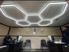 an empty room with chairs and lights on the ceiling