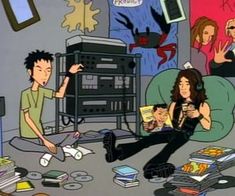 two people are sitting on the floor in front of a pile of books and cds