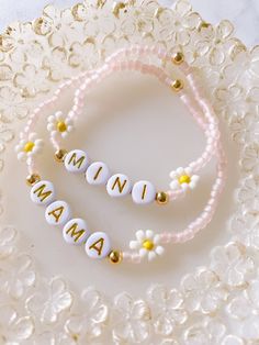 two personalized bracelets on a white lace plate with gold beaded beads and flowers