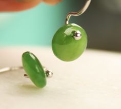 "Here are a pair of very cute nephrite jade \"dots\" earrings, set in sterling silver. Each gemstone has been carefully carved using A grade, bright green, gem quality nephrite jade and is finished with a high polish. These little jade drops measure approx. 8mm in diameter, hangs approx. 1/2\" total. These earrings are as cute as a button and are very fun to wear :) Please note that natural precious gemstones may include natural inclusions. Our jade is 100% genuine. We work with nephrite jade in Round Chrysoprase Earrings Gift, Green Jade Nickel-free Earrings, Green Nickel-free Jade Earrings, Nickel-free Green Jade Earrings, Green Oval Hypoallergenic Earrings, Hypoallergenic Green Oval Earrings, Green Cabochon Round Earrings, Green Round Cabochon Earrings, Jade Cabochon Earrings As A Gift