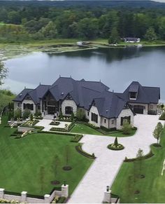 an aerial view of a large house with a lake in the background