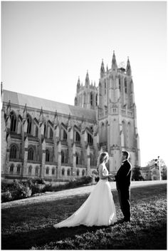 a bride and groom standing in front of a large building with tall towers on it