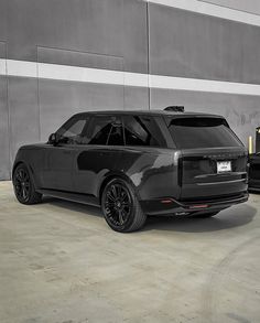 two black cars parked in front of a building with no one on the ground or people standing near them