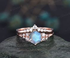 a diamond and blue stone ring sitting on top of a rock