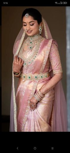 a woman in a pink and gold sari