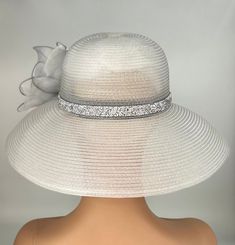 The featured hat is a  silver straw lightweight mesh hat.  The band around the hat is a bright sparkly silver bling strip. The hat is adorned with a  silver crinoline design. In the center of that design is a metal framed flower with wired clear rhinestones. The hat is so dramatic and evocatively romantic it's a must have for any woman who loves hats. Creating the look that suits you best comes from turning the hat on your head creating a different look with each twist till you find the look you love. This classic one of a kind hat made by Letty is a beautiful church hat or a Kentucky Derby Hat.   Also perfect  for  an Easter Hat, Tea Party hat,Wedding Party Hat, Fancy Dress hat, Downton Abby Hat and other special occasions. Brim:   6.5"" curved Rise:   4" Size:    Internal Draw String to Audrey Hepburn Hat, Hat Tea Party, Easter Hat, Downton Abby, Easter Hats, Hat Wedding, Church Hat, Tea Party Hats, Silver Bling