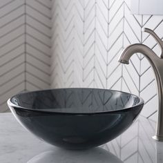 a black bowl sink sitting on top of a counter next to a faucet