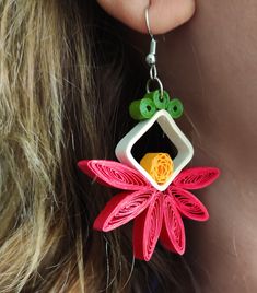 a close up of a woman's ear with earrings made out of paper flowers