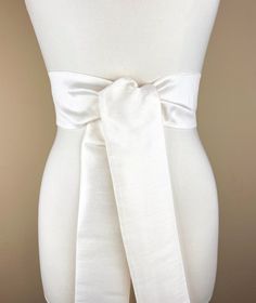 Wide Textured Off White Sash Belt  Off White Dupioni Sash  Light Ivory Dress Sash  Off White Fabric Belt  Wedding Dress Sash  Formal Sash  Add sophistication and crisp texture to your special occasion outfit with this Satin Swank® dupioni waist sash. Depending on your waist size and the length you choose (75 and 90 inch lengths available), you can wrap this sash around your waist once or twice. You decide whether to tie the sash in a bow or a simple knot with long-hanging tails. Tie in front, in back, or on the side. A double layer of crisp dupioni fabric in off white. Sash is the same front and back, seams are hidden within the fold lines, and ends are finished on the angle. Dupioni features a rustic weave with naturally occurring slubs and tiny thread loops running throughout the fabric White Fitted Dress With Belt, Fitted Sashes With Satin Bow, Elegant White Dresses With Sashes, Fitted Tie Back Sash For Evening, Fitted Evening Sash With Tie Back, Fitted White Bridal Belt, Wedding Sash With Tie Back, Elegant Cream Dress With Tie Waist, Satin Bridal Belt For Bridesmaids