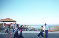 several people walking down the street with luggage