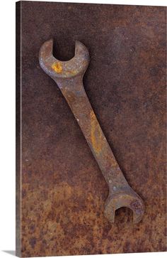 an old rusty wrench sitting on top of a rusted metal surface with yellow spots