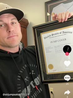 a man is holding up a framed award