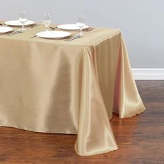 the table is set with white plates and silverware on it's placemats