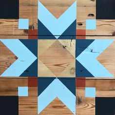 a wooden floor with blue, red and black geometric designs on the wood planks