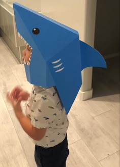 a young boy wearing a paper shark mask