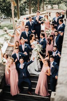 a large group of people posing for a photo on some steps with their arms in the air