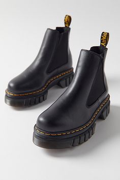 These newly-evolved Chelsea boots pack all the height of Dr. Martens’ renowned Quad platform into a cutting-edge, lightweight construction. Set on an innovative two-part sole – a lightweight EVA midsole and PVC outsole with rugged deep cleats – they bring less weight and more attitude. Marked with all the signature Doc DNA, including an amped-up edition of the unmistakable DMS tread pattern, as well as yellow welt stitching and a scripted AirWair heel loop. Content + Care Leather, EVA, PVC Spot clean Imported Size + Fit True to size Heel height: 1.875" Platform height: 1.5" | Dr. Martens Audrick Leather Platform Chelsea Boot in Black, Women's at Urban Outfitters Doc Marten Platform, Doc Marten Chelsea, Dr Martens Audrick, Platform Doc Martens, Dr Martens Chelsea, Chelsea Boots Outfit, Doc Marten Boot, Dr Martens Outfit, Platform Chelsea Boots