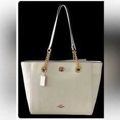 New Coach Pebble Turnlock Chain Tote Bag The Customer-Favorite Turnlock Tote Is Updated With Polished Grommets And Chains To Add A Little Edgy Femininity. Thoughtful Details Like A Drop-In Zipper And Hidden Front Interior Pocket Add Function To The Fashion. Polished Pebble Leather.Closure. Elegant Cream Bag With Chain Strap, Luxury Everyday Cream Shoulder Bag With Gold-tone Hardware, Timeless White Bag With Metal Hardware, Timeless White Bags With Metal Hardware, Elegant Tote Shoulder Bag With Chain, Elegant Shopping Bag With Chain Detail, Elegant Shopping Bags With Chain Detail, Elegant Tote Bag With Chain, Elegant Chain Shoulder Bag Tote