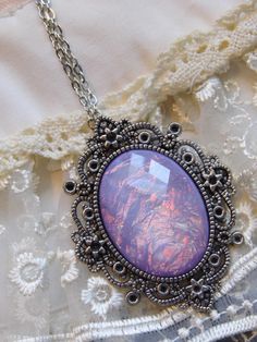 JUST LISTED - Vintage Inspired - Georgian & Victorian Cameo Jewlery - Lavender purple Moonstone FIre Opal OOAK Victorian princess Fantasy glass art Mythical Necklace Altered Art substantial in size at just a little over 2 INCHES Long Center is 40mmx30mm **thank you for taking the time to look at our items. Each item is handcrafted and attention to detail - We send each item in bubble packaging and with tracking to make sure items arrive in perfect condition. Please feel free to check out our Handmade Purple Fantasy Necklaces, Handmade Purple Fantasy Necklace, Purple Fantasy Necklace For Gift, Fantasy Style Purple Necklace For Gift, Purple Handmade Magical Jewelry, Handmade Magical Purple Jewelry, Magical Purple Pendant Necklace, Artistic Purple Pendant Jewelry, Artistic Round Purple Jewelry