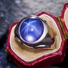 This striking vintage mens ring features an awesome lab created star sapphire cabochon flush set into a sturdy and stylish 10K white gold mounting. The ring is currently size 11.5 and it weighs 12.1 grams.  There is a slightly visible sizing bar from a previous sizing that will be fixed when sized for the lucky new owner. Sapphire Cabochon Ring, Sapphire Cabochon, Blue Star Sapphire, Ring White Gold, Star Sapphire, Cabochon Ring, Mens Ring, Blue Star, White Ring