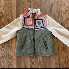 a child's jacket sitting on top of a wooden floor