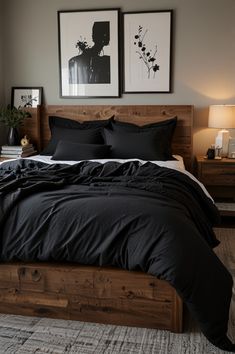 a bed with black comforter and pillows in a bedroom next to two pictures on the wall