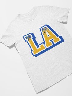 Los Angeles Football Retro Sports Letters Tee Shirt Makes a great gift for Father's Day, Mother's Day, Birthdays and for retro 90's parties. Celebrate 90's and 80's retro pop culture in style. The unisex heavy cotton tee is the basic staple of any wardrobe. It is the foundation upon which casual fashion grows. All it needs is a personalized design to elevate things to profitability. The specially spun fibers provide a smooth surface for premium printing vividity and sharpness. No side seams mean Pop Culture Letter Print Shirt, Sports Letters, Retro Pop Culture, Football Retro, Retro Sports, Retro Sport, Retro Pop, 80s Retro, Retro 90s