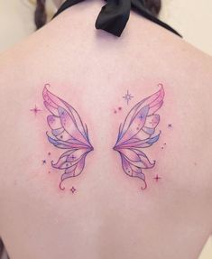 a woman's back with two butterfly tattoos on it