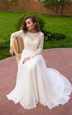 a woman in a white dress sitting on a chair