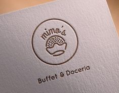 a close up of a logo on a piece of paper with the words,'mima's buffet & doceria '