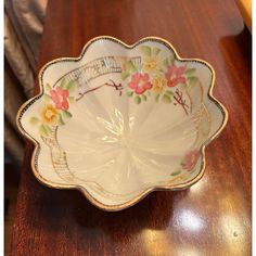 a white plate with flowers on it sitting on a wooden table