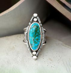 Unique, bold turquoise ring for her. The setting is a Kingman, deep blue turquoise oval surfboard cabochon that is 1.75" x 5.8" and in a Bezel embellished setting. The 925 Sterling Silver has been fused, stamped and oxidized. The tapered wide band is 3/4" then narrows to 1/8" and cannot be resized. Size 8 This handmade boho chic statement ring is one of a kind showcasing the beauty of Kingman Turquoise. Whether you're shopping for yourself or are searching for the one of a kind gift for mom, wife, girlfriend or friend look no further.  The holidays are right around the corner so shop early for the best selection. Caring for your turquoise jewelry:  To protect your turquoise jewelry, we recommend that you put jewelry on after applying makeup, sunscreen and perfume, and never wear your jewel Antique Turquoise Jewelry, Turquoise Statement Ring, Antique Turquoise, Casual Rings, Vero Beach Fl, Southwest Jewelry, Precious Jewels, Vero Beach, Statement Ring Silver