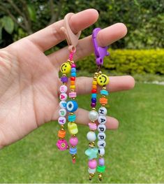 a person is holding some colorful beads in their hand with the words happy on them