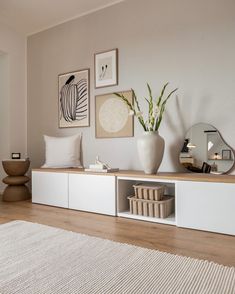 a living room filled with furniture and pictures on the wall next to a rug in front of a window