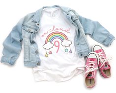 a pair of pink tennis shoes next to a denim jacket and white t - shirt