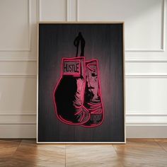 a neon sign with a boxing glove on it in front of a white wall and wooden floor